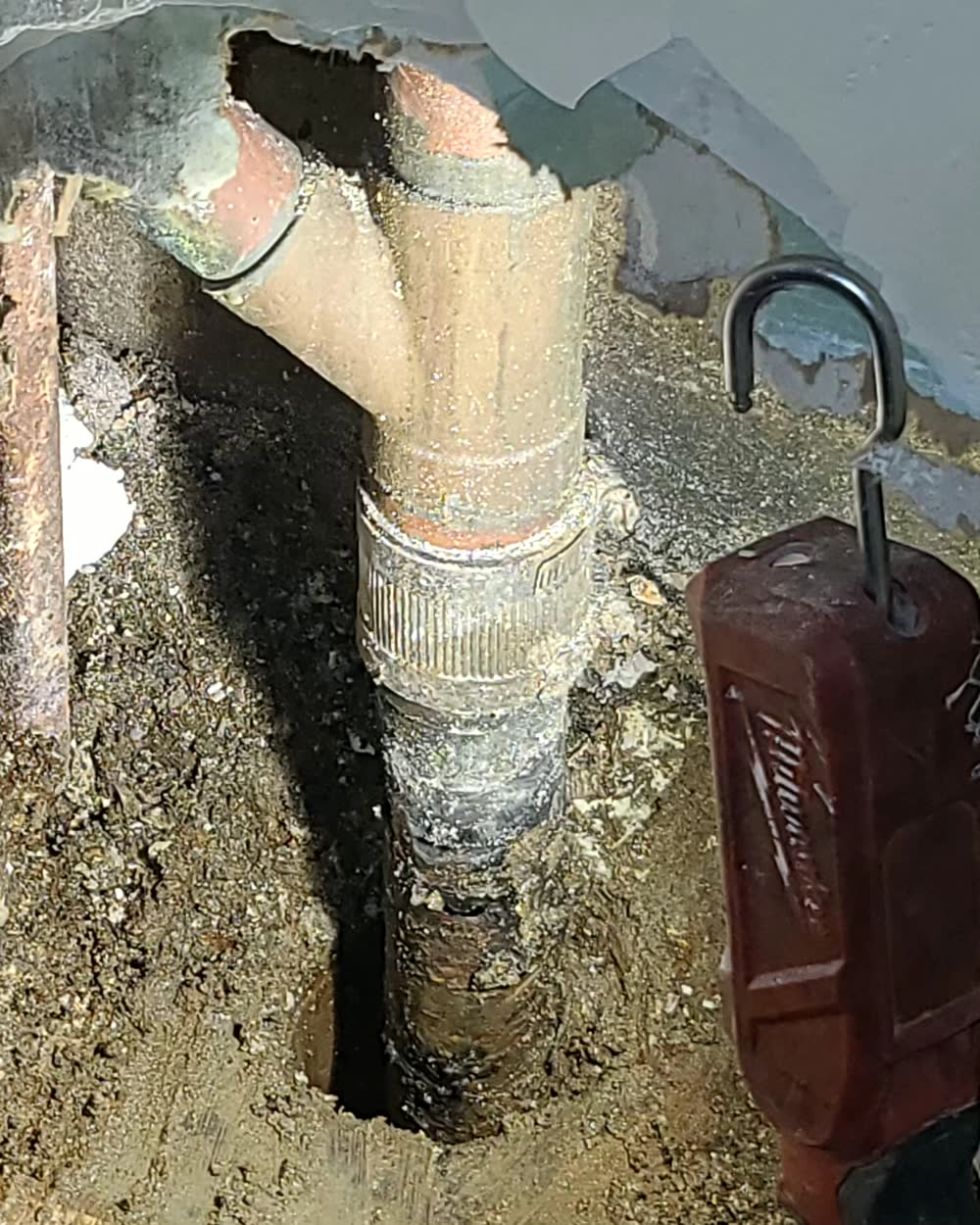 An old cast-iron drain dug out below a basement floor