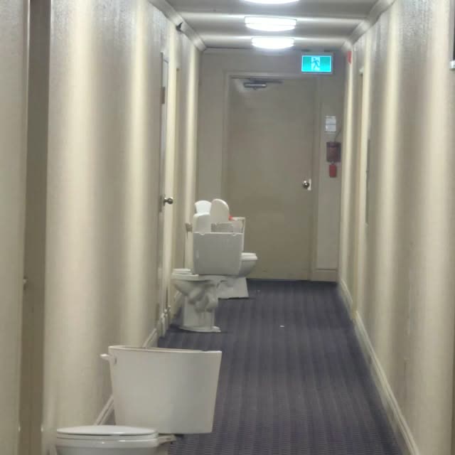 New toilets lined up in a hallway for a multi-unit replacement